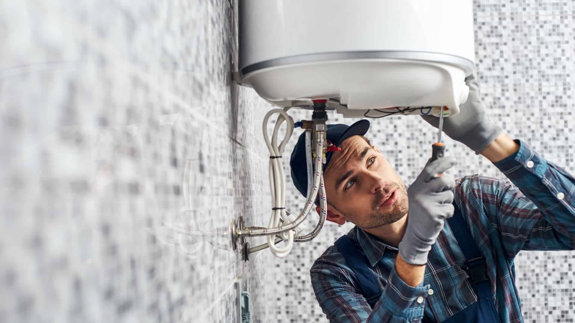 Monteur bei der Arbeit an einem Warmwasserspeicher